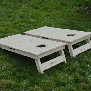 cornhole 2 planches bois naturel avec veinage et nœuds apparents, sur le gazon, vue de derrière