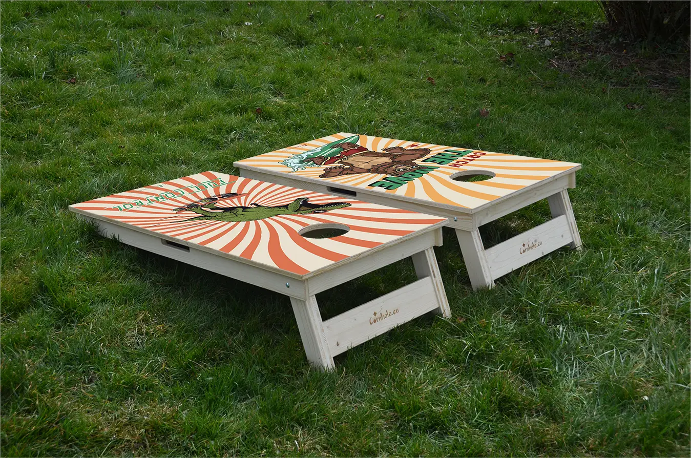 cornhole 2 planches ours surfeur et t-rex skateur, sur le gazon, vue de derrière