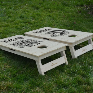 cornhole 2 planches surfeur dans un tube et totem hawaïen, sur le gazon, vue de derrière