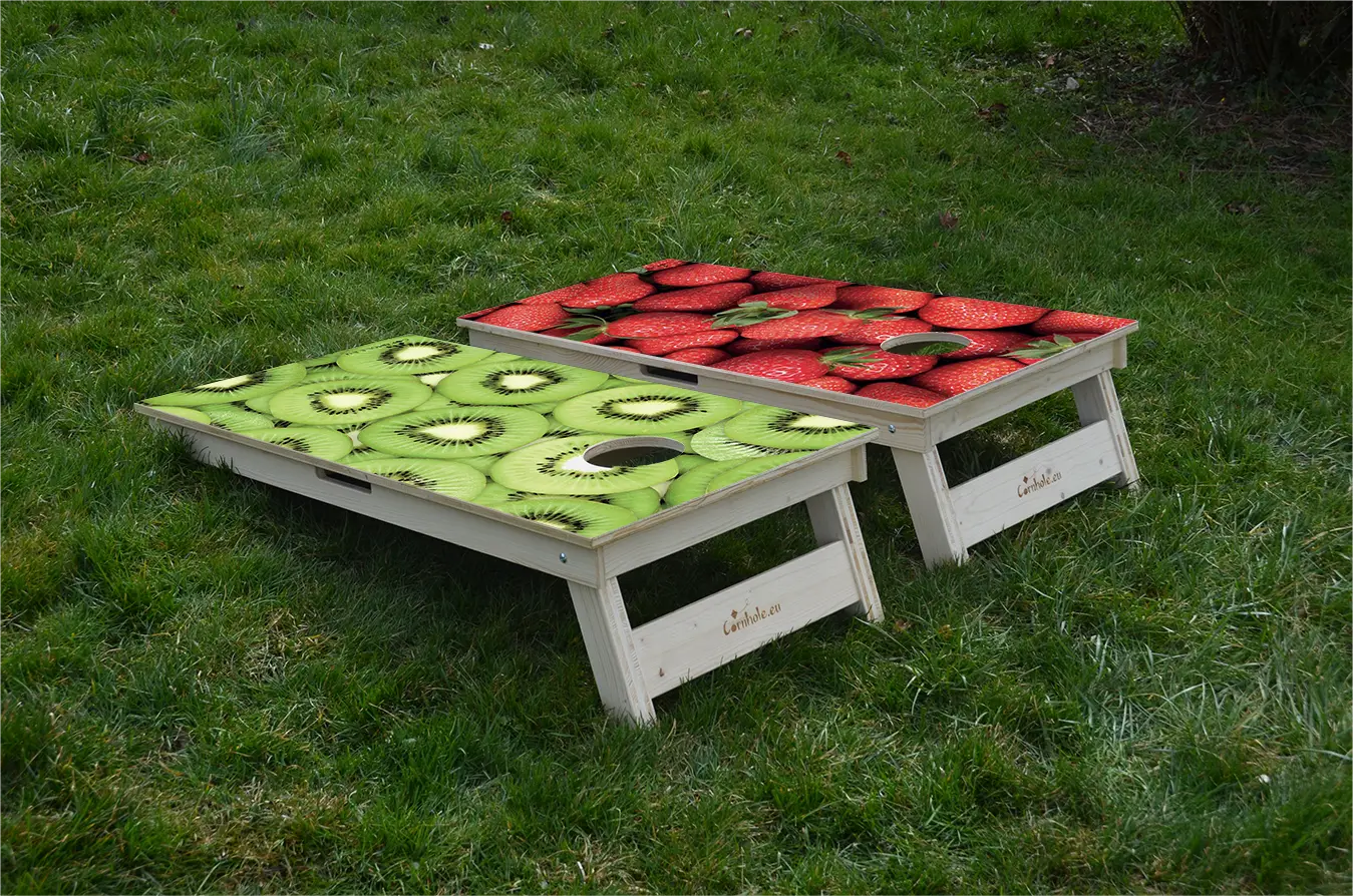 cornhole 2 planches fraises et kiwis, et encore des fraises et encore des kiwis, sur le gazon, vue de derrière