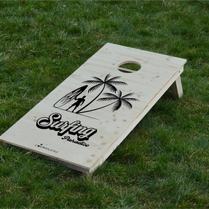 cornhole surfeur avec sa planche sous les palmiers, sur le gazon, vue de face
