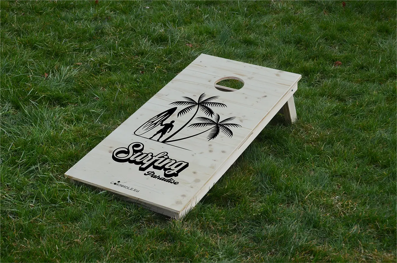 cornhole surfeur avec sa planche sous les palmiers, sur le gazon, vue de face