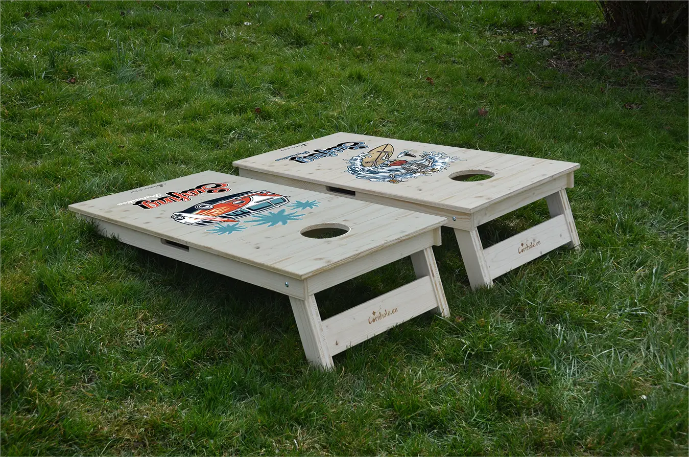 cornhole 2 planches van de surf et squelette surfant une vague, sur le gazon, vue de derrière